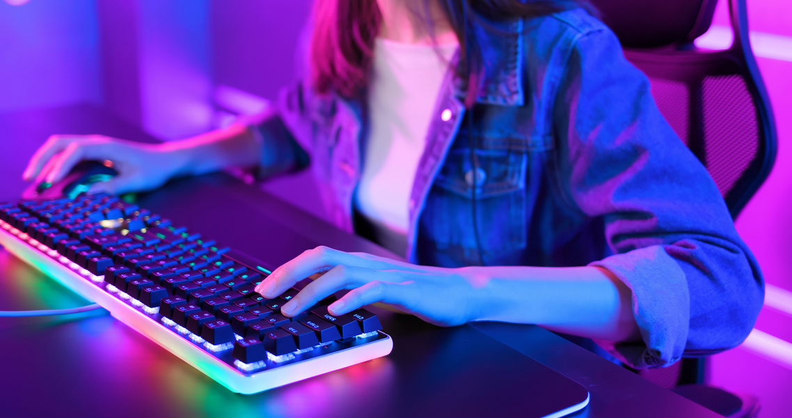Girl Playing Video Games Using  RGB Gaming Keyboard